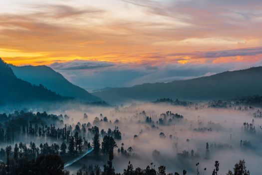Stunning sunrise over misty mountains in East Java, Indonesia, capturing nature's beauty.