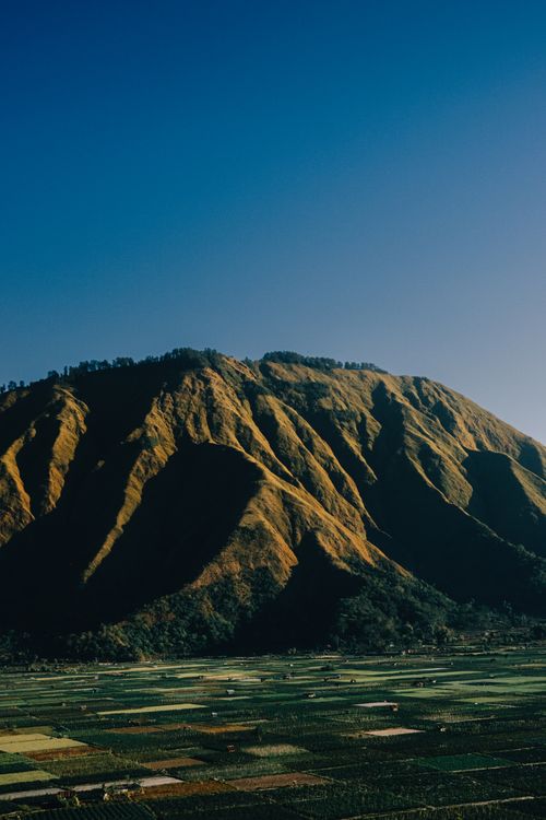 Free Stunning view of green hills and valleys under a clear blue sky in West Nusa Tenggara, Indonesia. Stock Photo