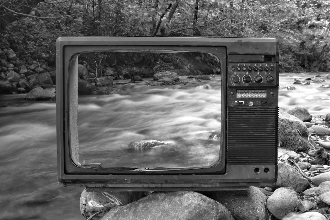 Gratis Tv Retro En La Orilla Del Río Cerca Del Bosque Foto de stock
