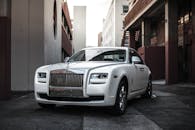 一辆优雅的白色豪车停在小巷中，散发着精致与时尚的气息