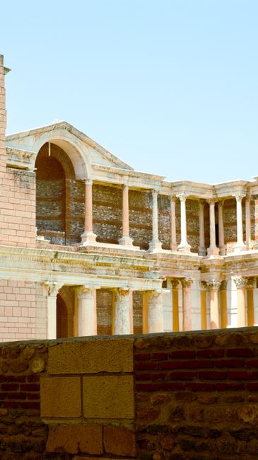 Fotomural Explora las majestuosas ruinas de un antiguo teatro romano con columnas bien conservadas bajo un cielo azul despejado.
