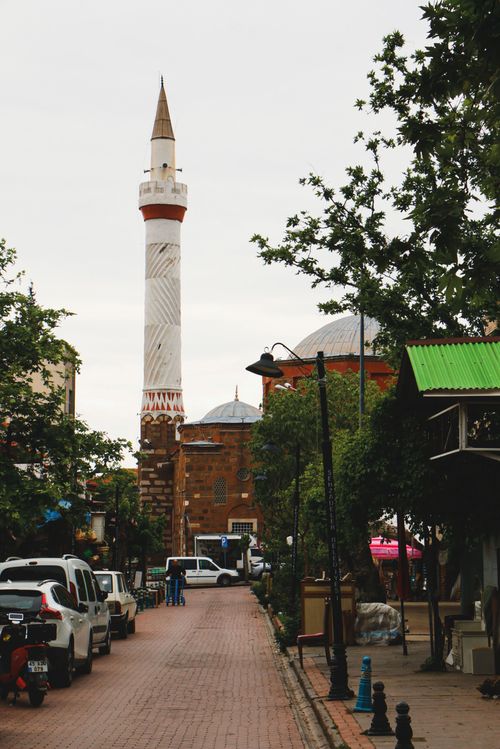 Free A street view of a mosque with a historic minaret in a bustling city area. Stock Photo