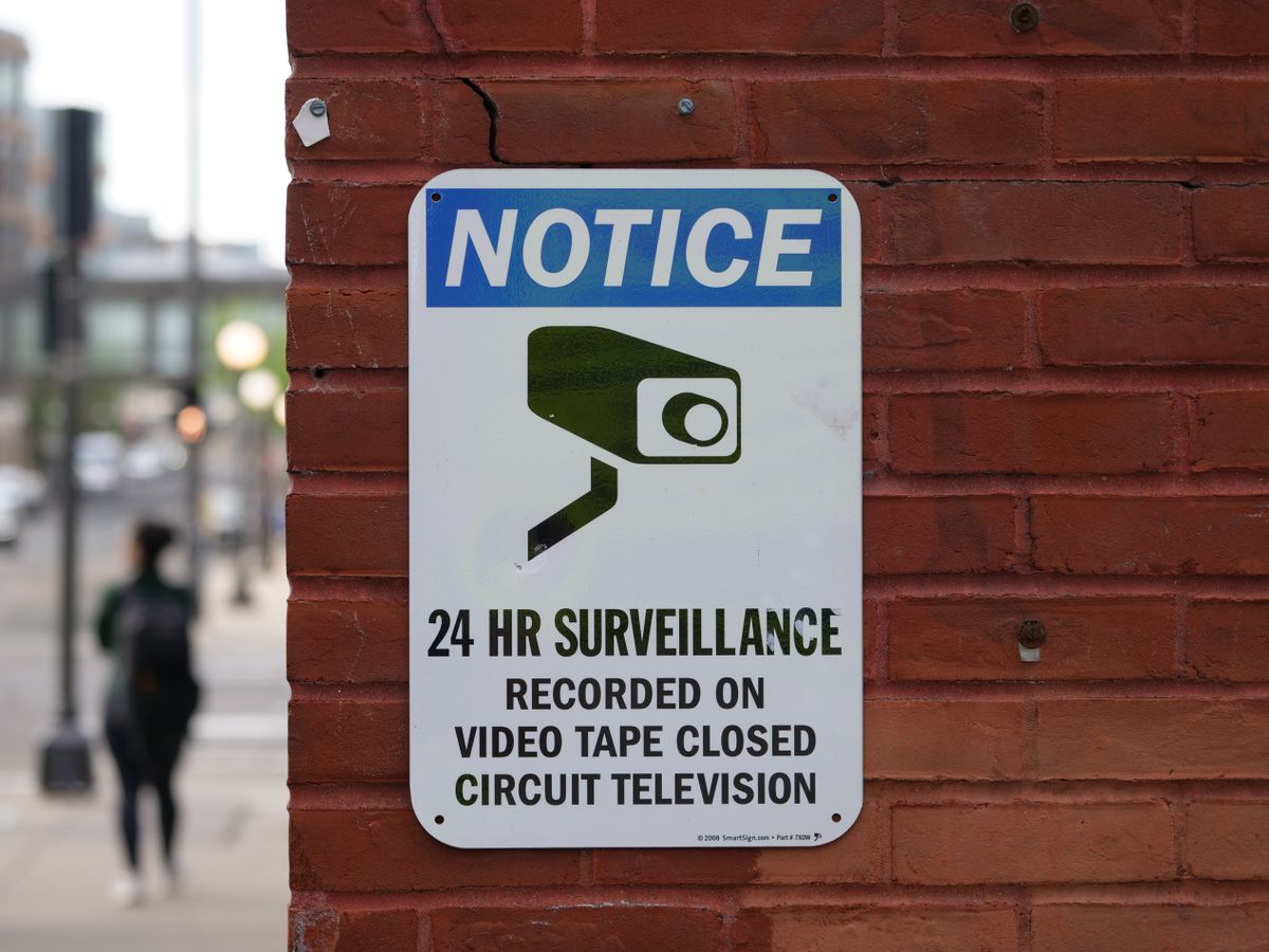 CCTV surveillance notice displayed on an exterior brick wall