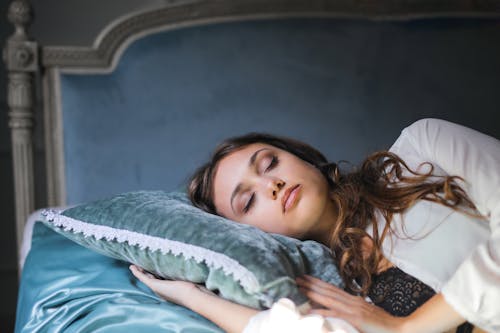 Foto Del Primo Piano Della Donna In Veste Di Seta Bianca Che Dorme Su Un Letto