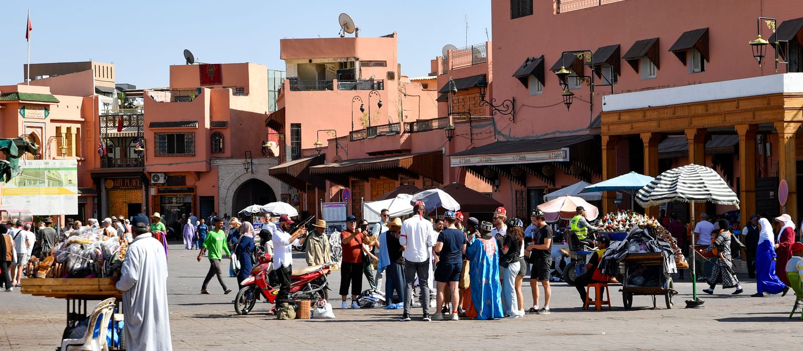 Lively market scene in Marrakesh with people shopping in Jemaa el-Fnaa square on a sunny day. — flights from Lille to Marrakech
