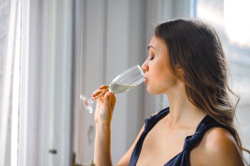 Free Selective Focus Side View Photo of Woman in a Black Top Drinking  Champagne Stock Photo