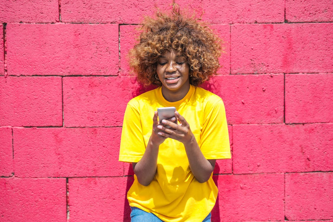 Woman in Yellow Shirt Holding Cellular phone