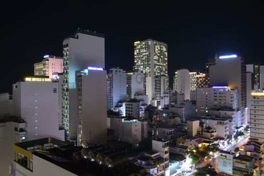 A vibrant city skyline illuminated by bright lights at night, showcasing urban architecture.