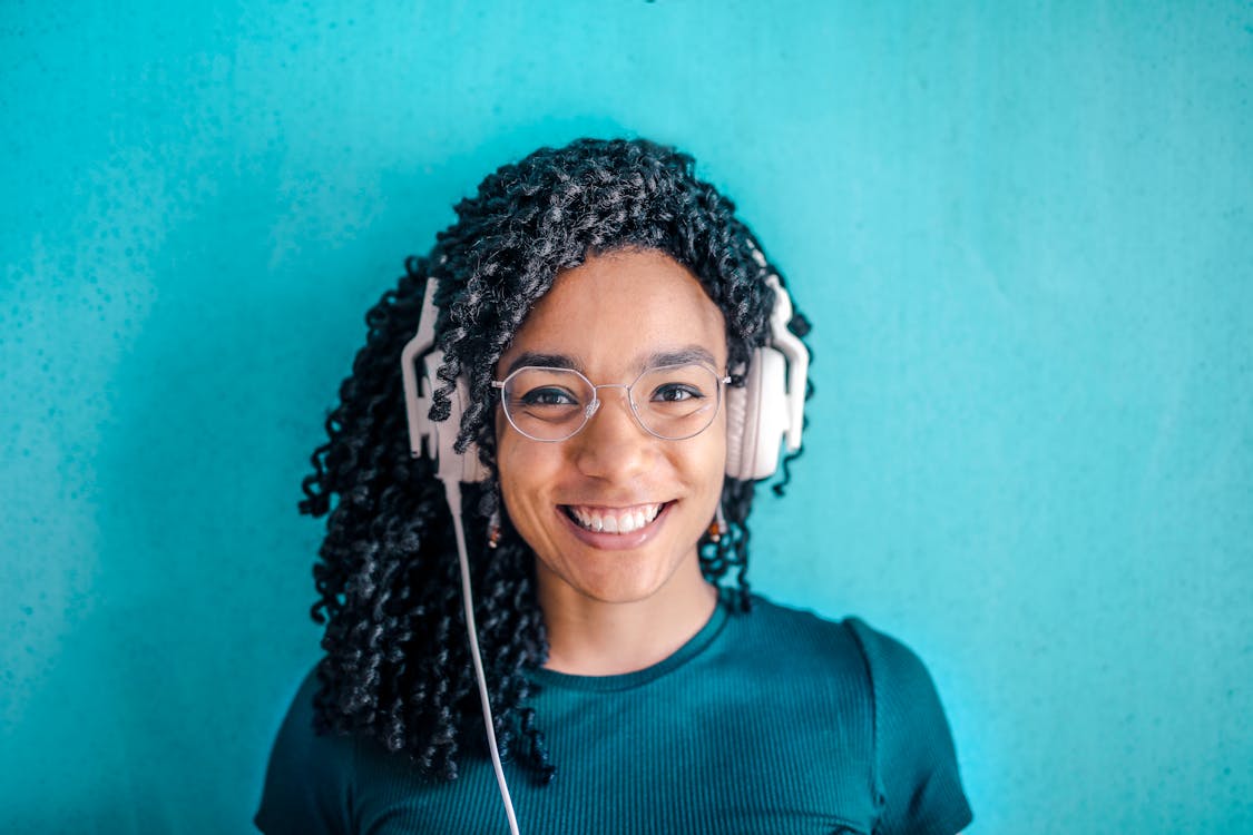 Free Portrait Photo of Smiling Woman in Black T-shirt ans Glasses Wearing White Headphones Stock Photo