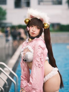 A young woman in intricate cosplay near a pool, showcasing creative costume design.
