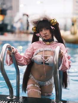 A woman in playful cosplay attire emerges from a swimming pool, blending fantasy and leisure.