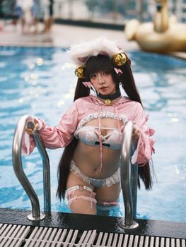 A person in detailed cosplay attire poses by a swimming pool.