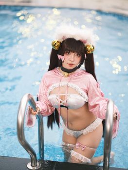 A woman poses in a playful cosplay costume by the pool, showcasing creativity and style.