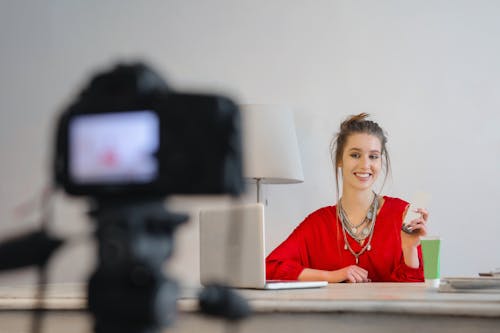 Free Woman in Red Shirt Sitting by the Table Stock Photo