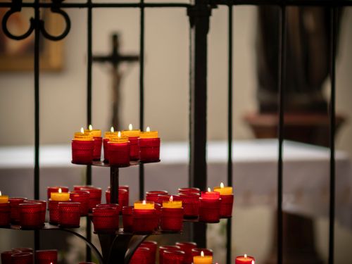 Free Warm ambiance with red votive candles and cross in a Polish church indoors. Stock Photo