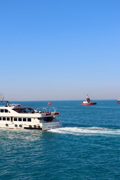 Free Scenic view of a passenger ferry cruising on a serene blue sea with a clear sky. Stock Photo