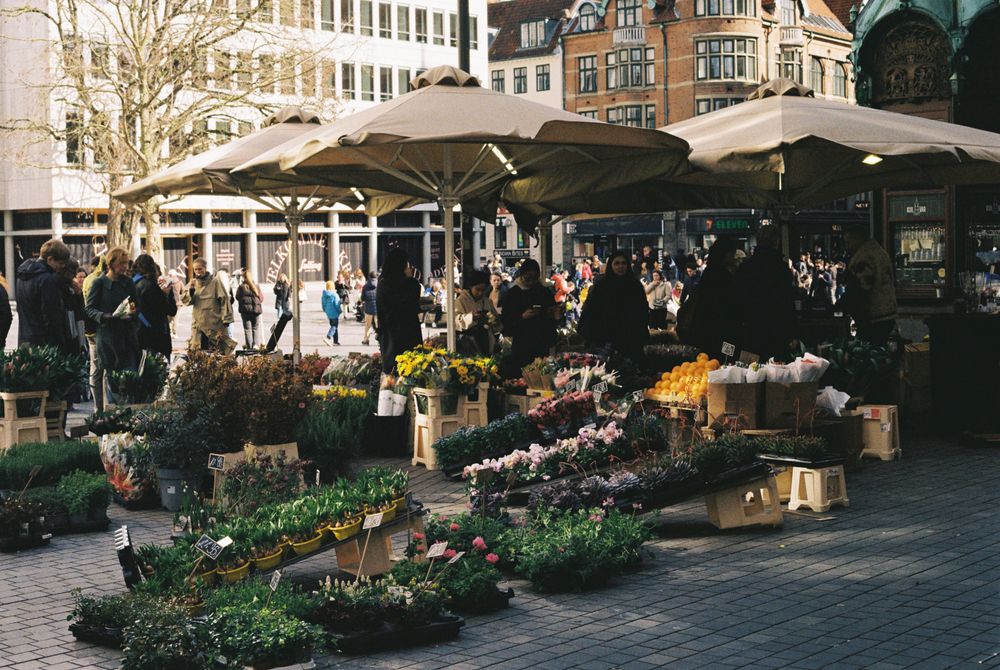 Piață de flori aglomerată, cu buchete colorate și cumpărători, în Copenhaga