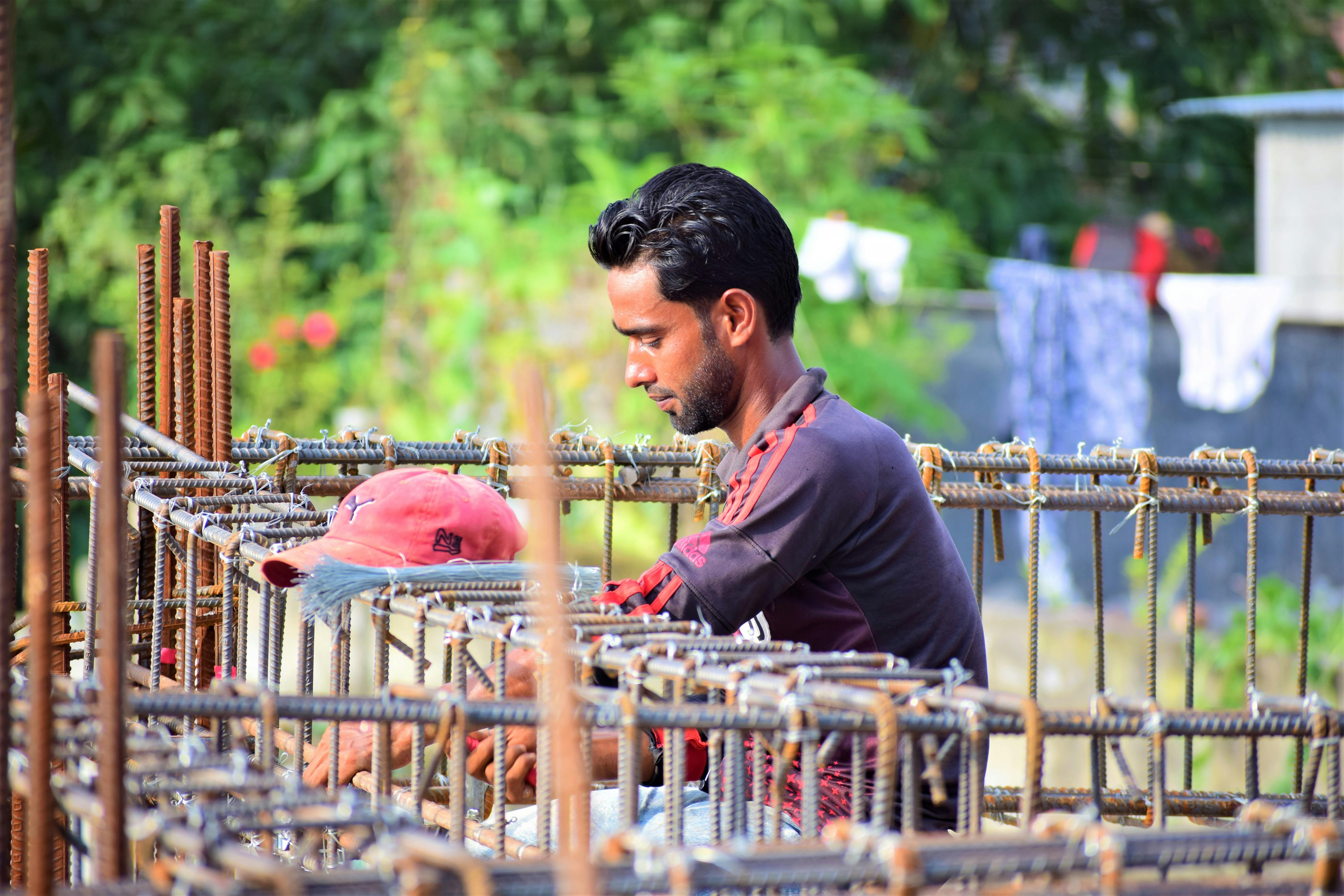 A dedicated worker focuses on construction tasks in Mymensingh, Bangladesh.