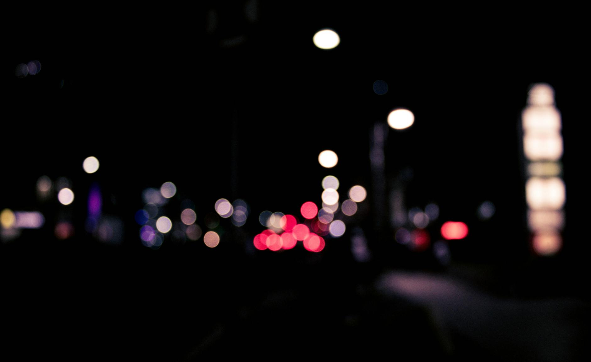 Blurred urban nighttime scene with colorful bokeh lights creating a dreamy effect.
