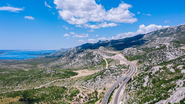 Aerial view of a winding highway through mountainous terrain with the Adriatic Sea in Croatia.