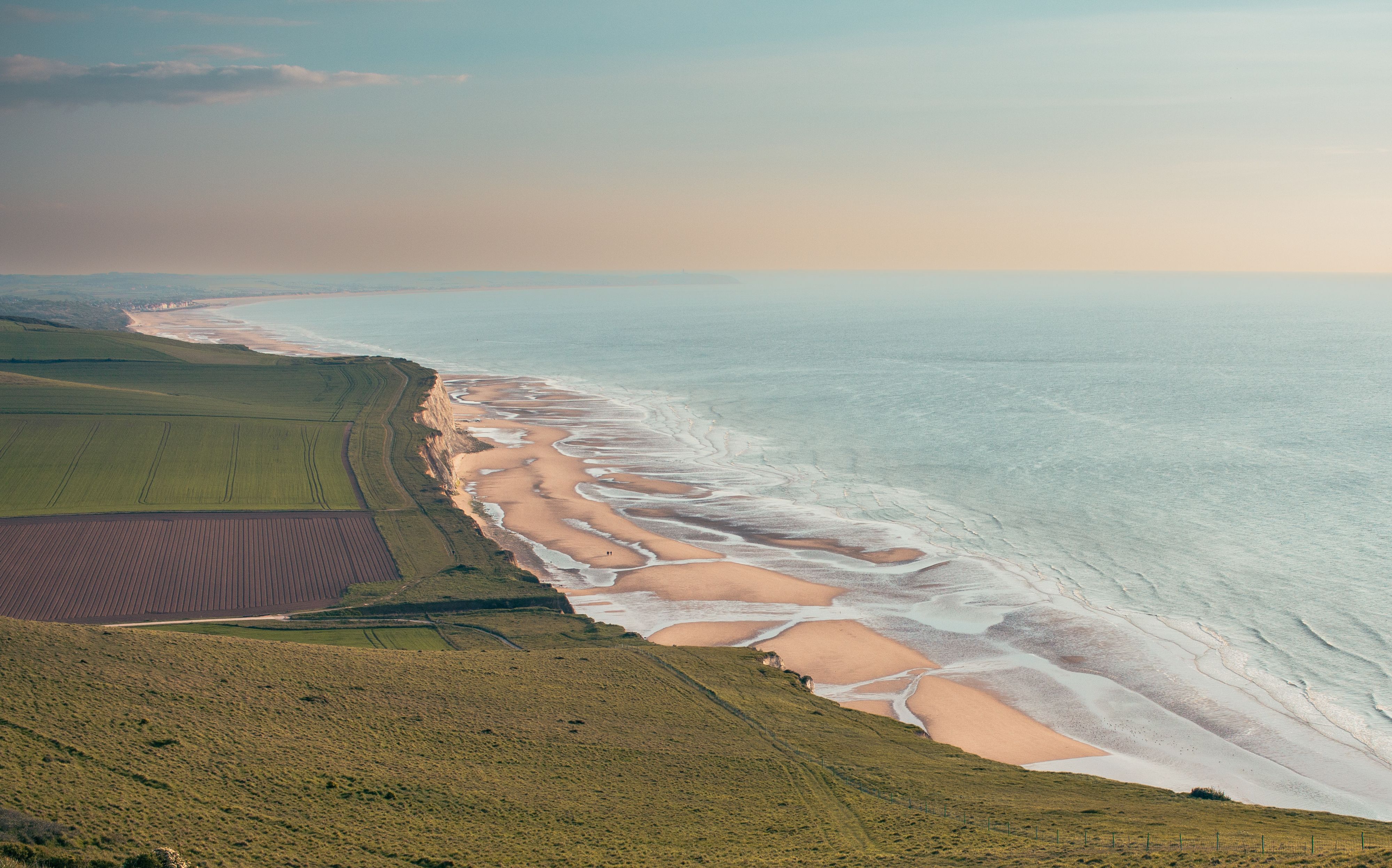 A breathtaking view of the coastline in Hauts-de-France, showcasing rolling fields and sandy beaches.