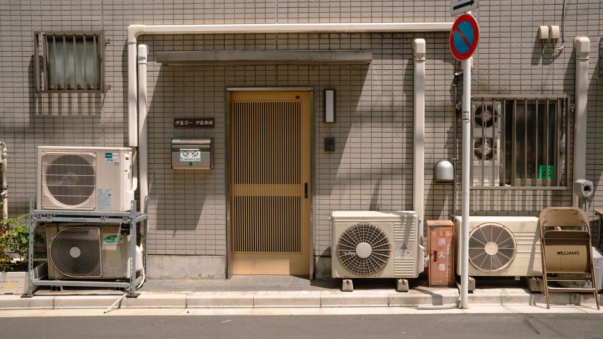 室外機が並ぶ低層の集合住宅の入口