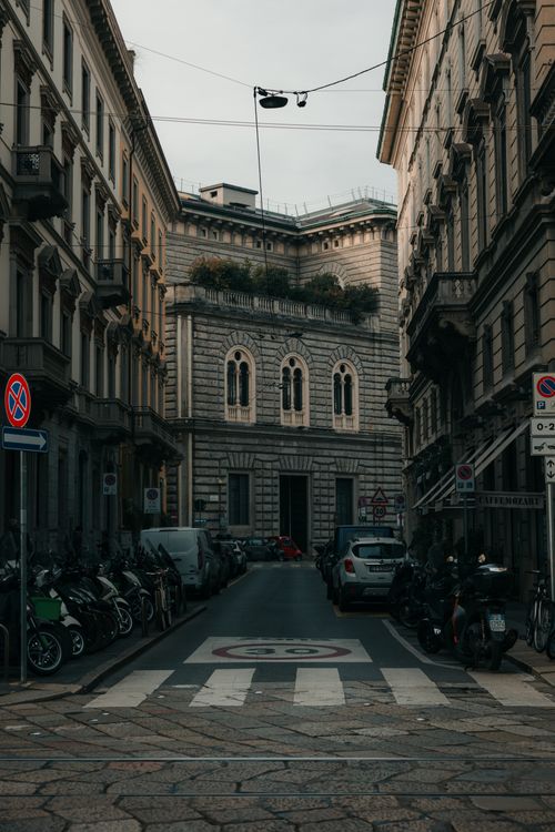 Free Charming historic street in Milan, showcasing classic European architecture under a moody sky. Stock Photo