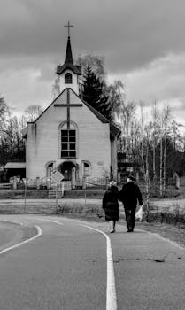 黑白照片中，两个人走向教堂，捕捉到平静与信仰