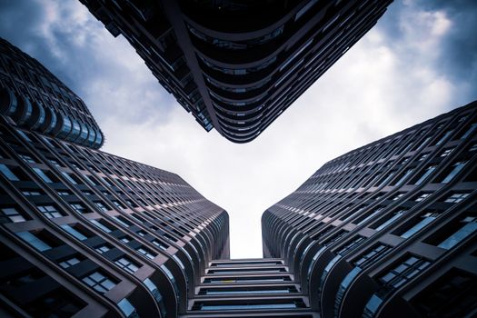 Dramatic view of modern skyscrapers under a cloudy sky in Warsaw, Poland.