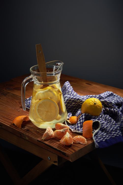 Free A vibrant still life of lemonade with citrus fruit slices and a wooden spoon on a rustic table. Stock Photo