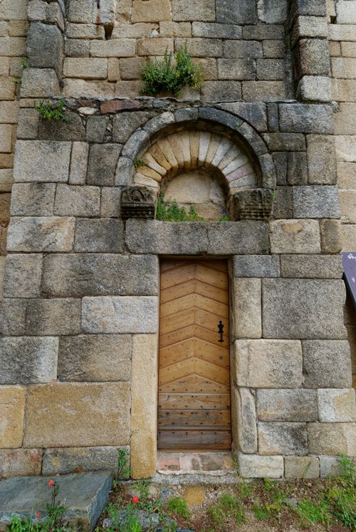 Free Charming ancient stone wall with an arched wooden door in a French village. Stock Photo
