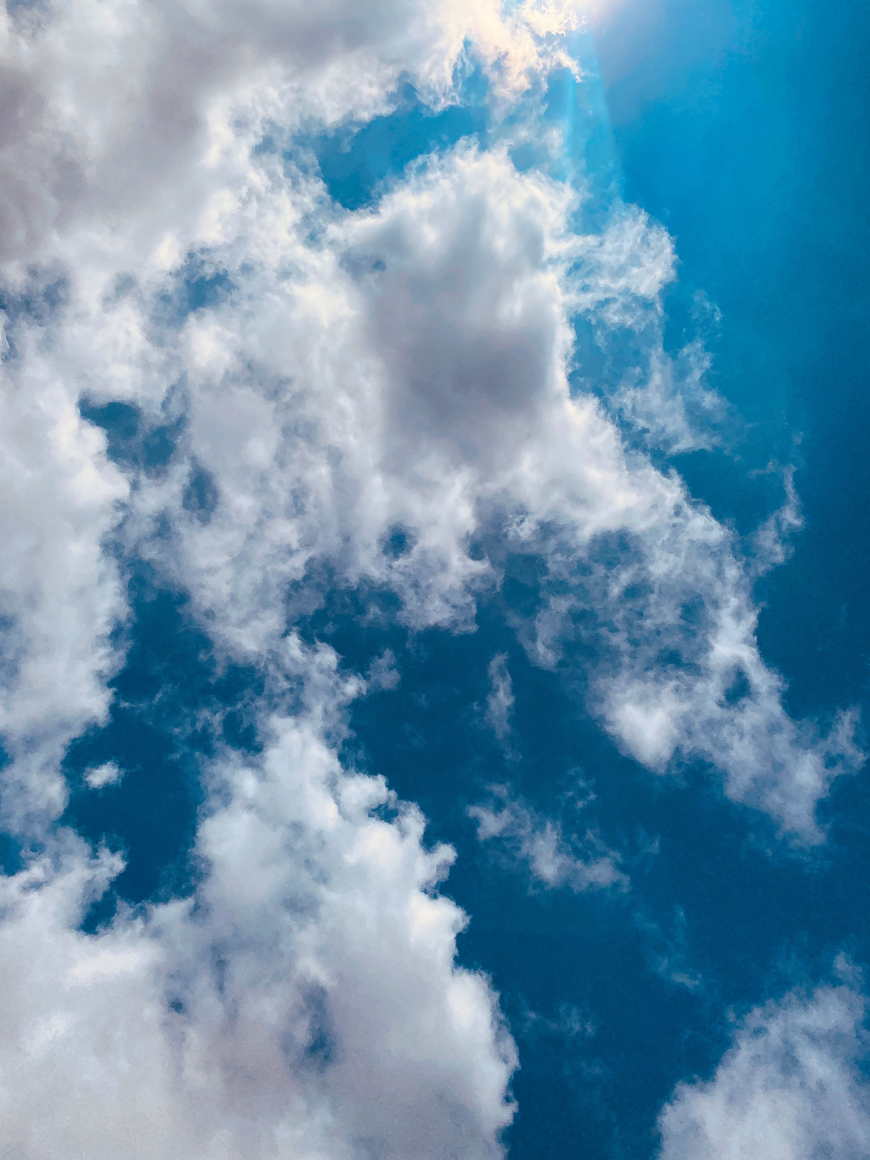 Vivid image of fluffy white clouds against a clear blue sky, perfect for backgrounds.