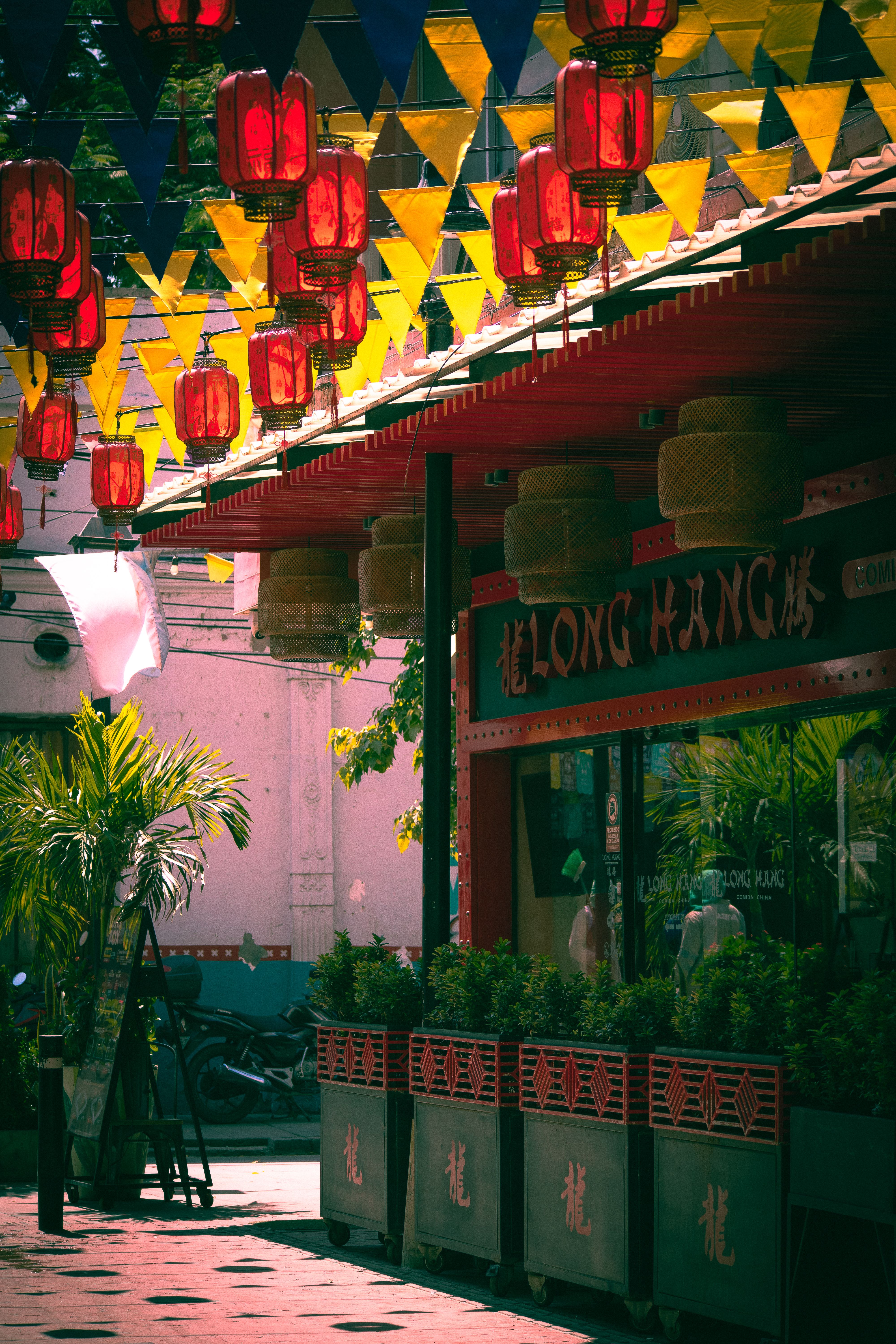 Colorful street scene with red lanterns and flags creating a festive atmosphere in Santa Marta, Colombia.