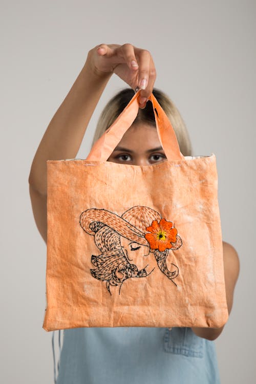 女人抱著橙色的袋子