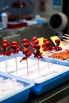 Fresh octopus skewers on display at a vibrant Kyoto, Japan street market.