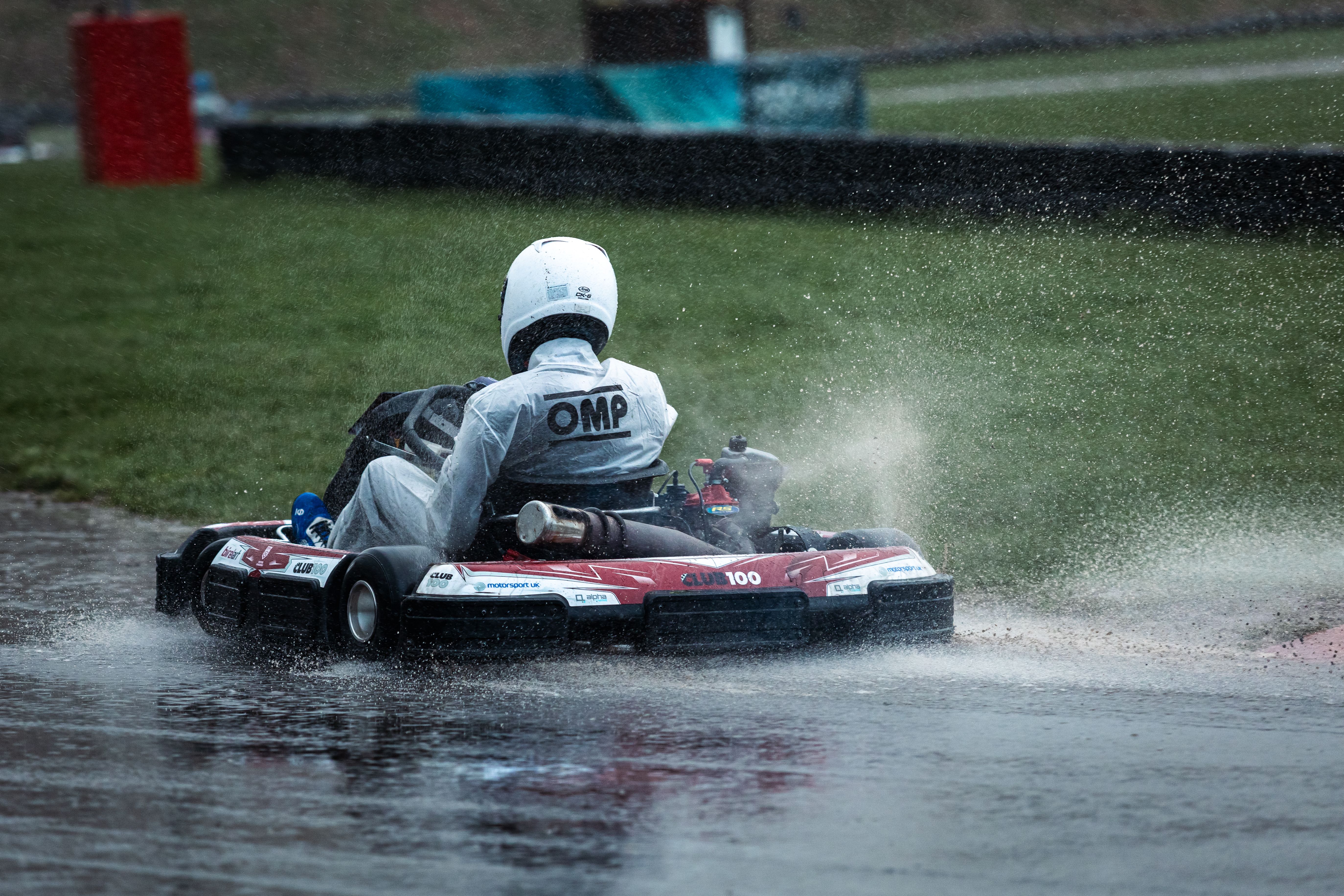 Thrilling go-kart race on a wet track, capturing the spray and speed of a competitive driver.