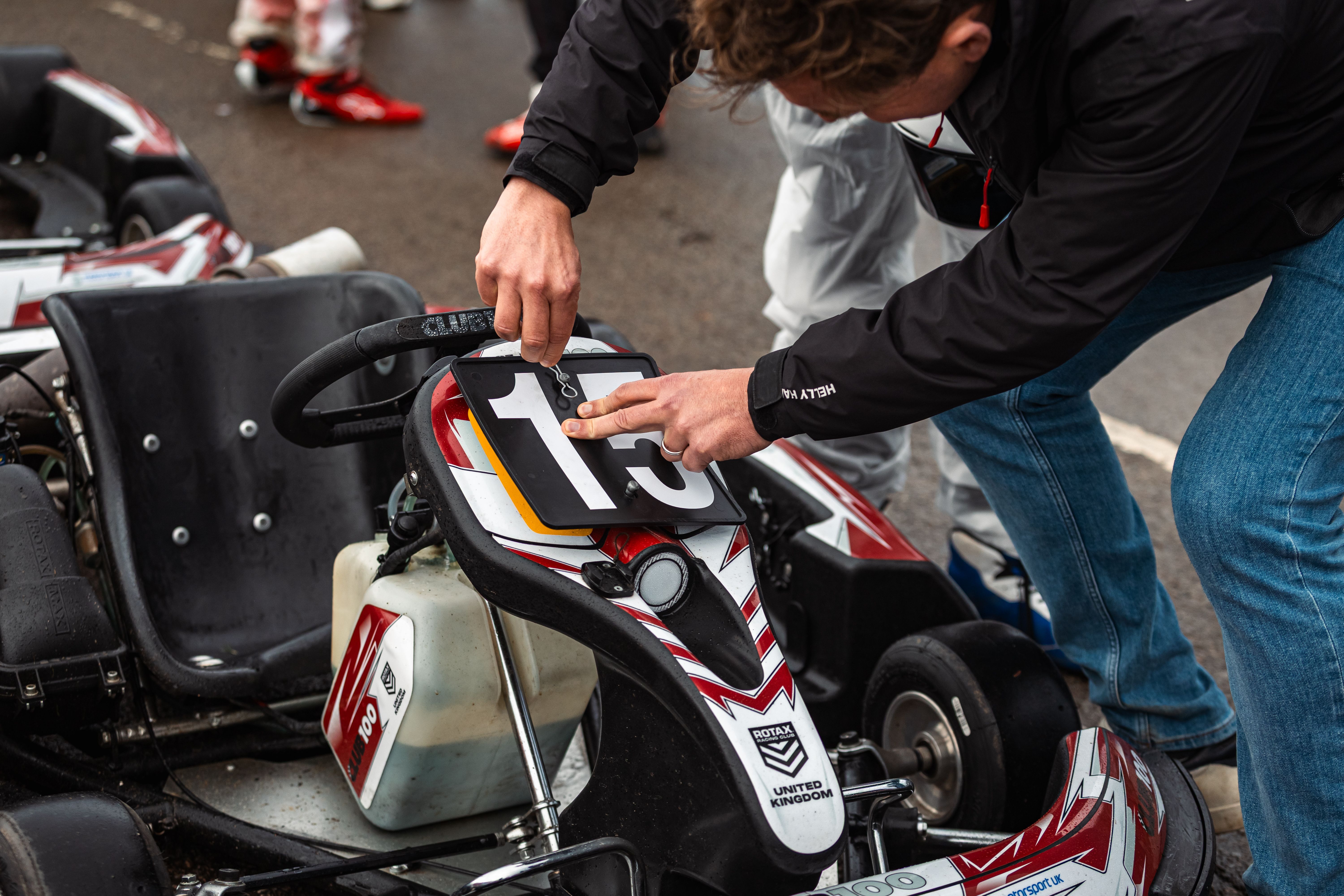 Mechanic Adjusting Go-Kart Number Plate
