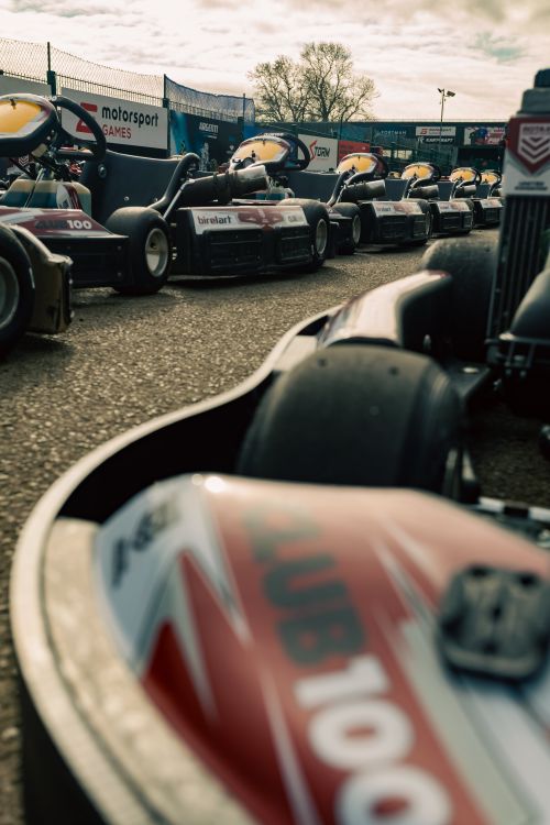 Free A dramatic view of go-karts lined up for a race under a clear sky, showcasing competitive spirit and anticipation. Stock Photo