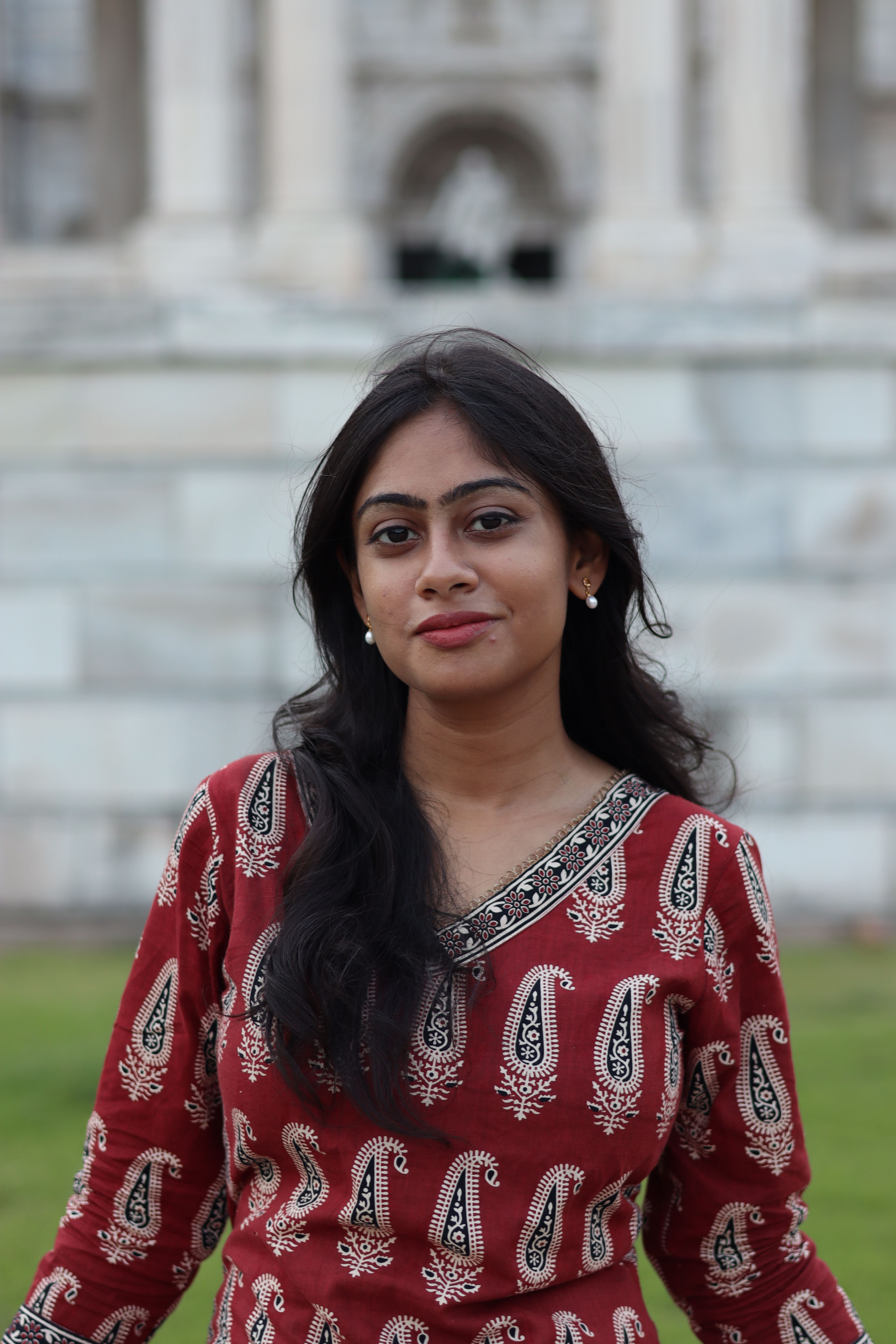 Elegant South Asian woman in traditional attire in front of Victoria Memorial, Kolkata.