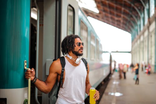 Man in White Tank Top Holding Yellow Tin Can