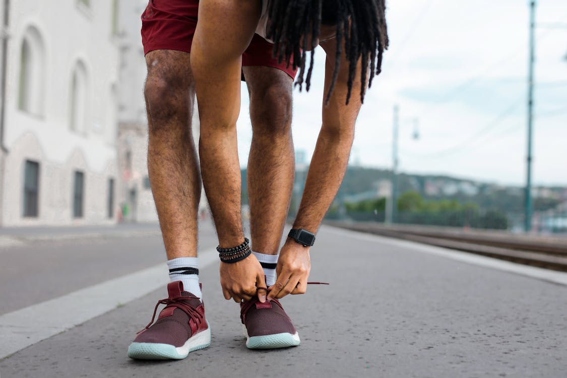 Person in Red Shorts and Black and Red Sneakers