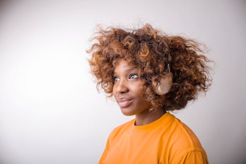 Mujer En Camisa De Cuello Redondo Naranja Con Auriculares