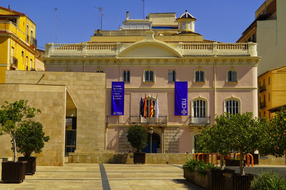 Vista panorámica de un edificio histórico en Valencia, que muestra su arquitectura clásica bajo un cielo azul despejado.