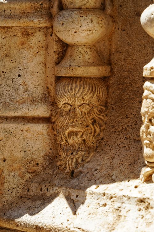 Free Historic stone carving of a human face in Valencia, Spain, depicting classical art styles. Stock Photo