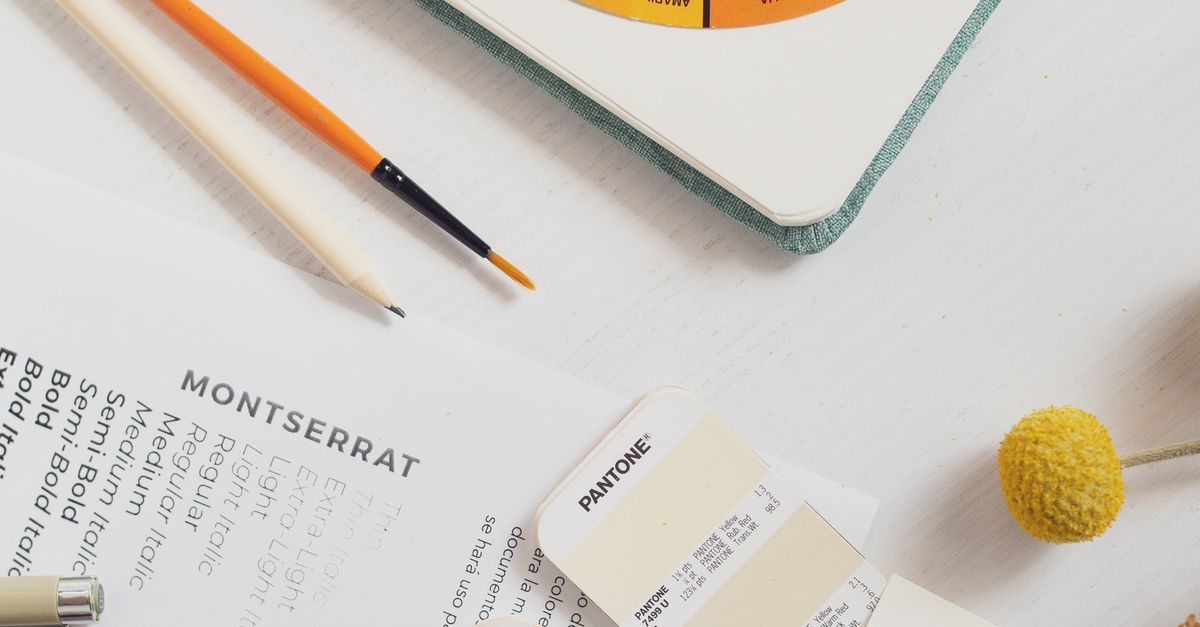 Top view of a creative workspace featuring color swatches, pencils, and design materials, ideal for branding projects.