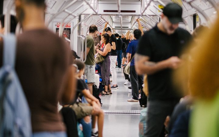 A bustling scene of diverse commuters inside a São Paulo subway train.