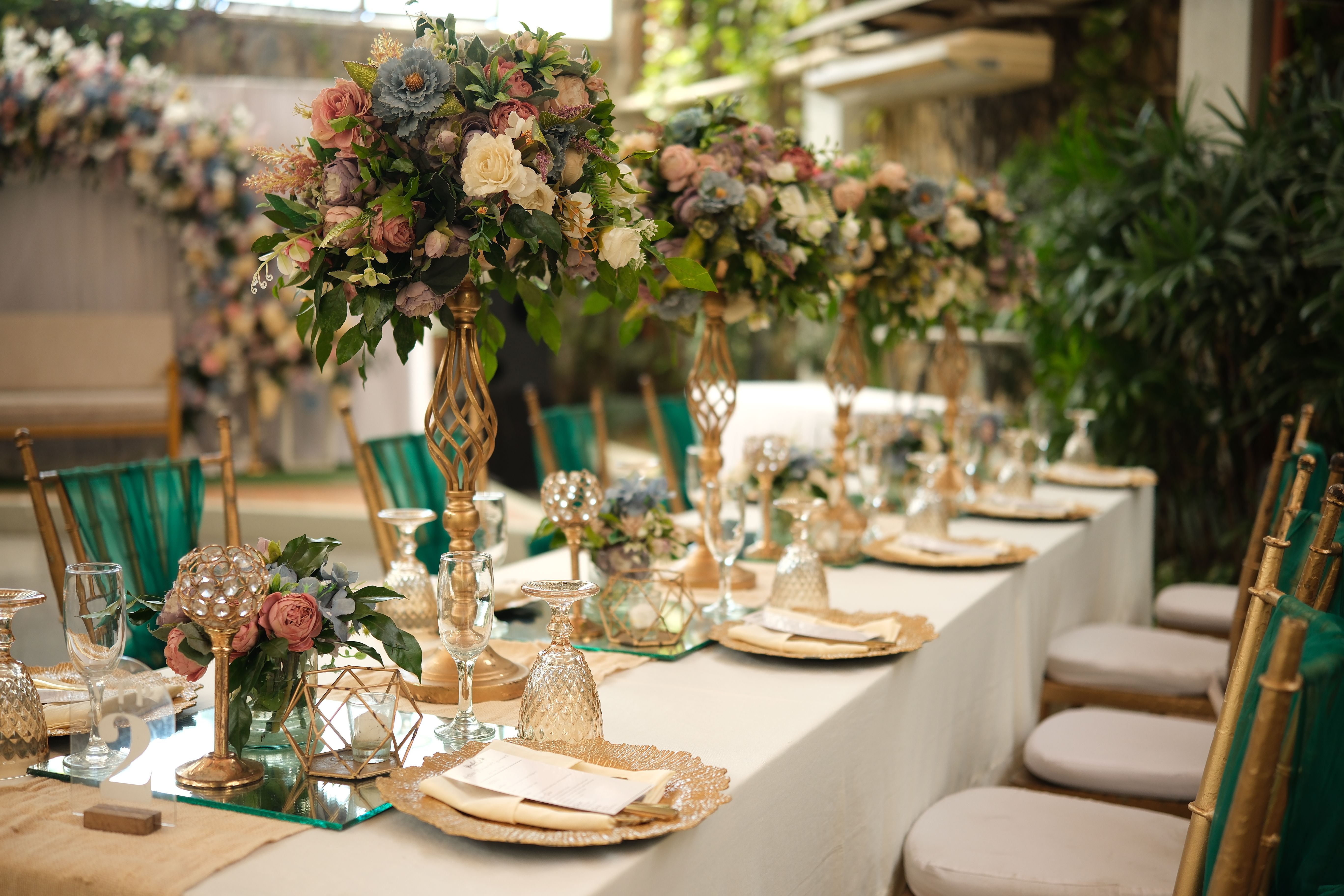 Outdoor wedding reception in Las Piñas with elegant table setting and lush floral arrangements.