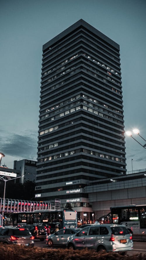 Free Modern skyscraper against gray sky in downtown during evening Stock Photo