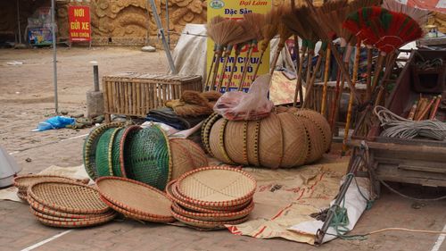 Free Rustic Vietnamese market scene with baskets, brooms, and local handicrafts on display. Stock Photo