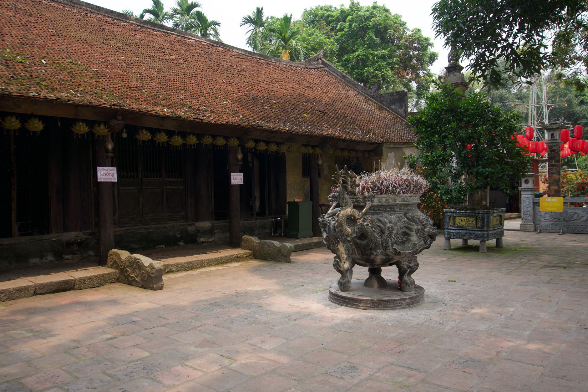 Peaceful courtyard of cultural heritage temple in Hung Yen, Vietnam, showcasing traditional architecture and incense burner.